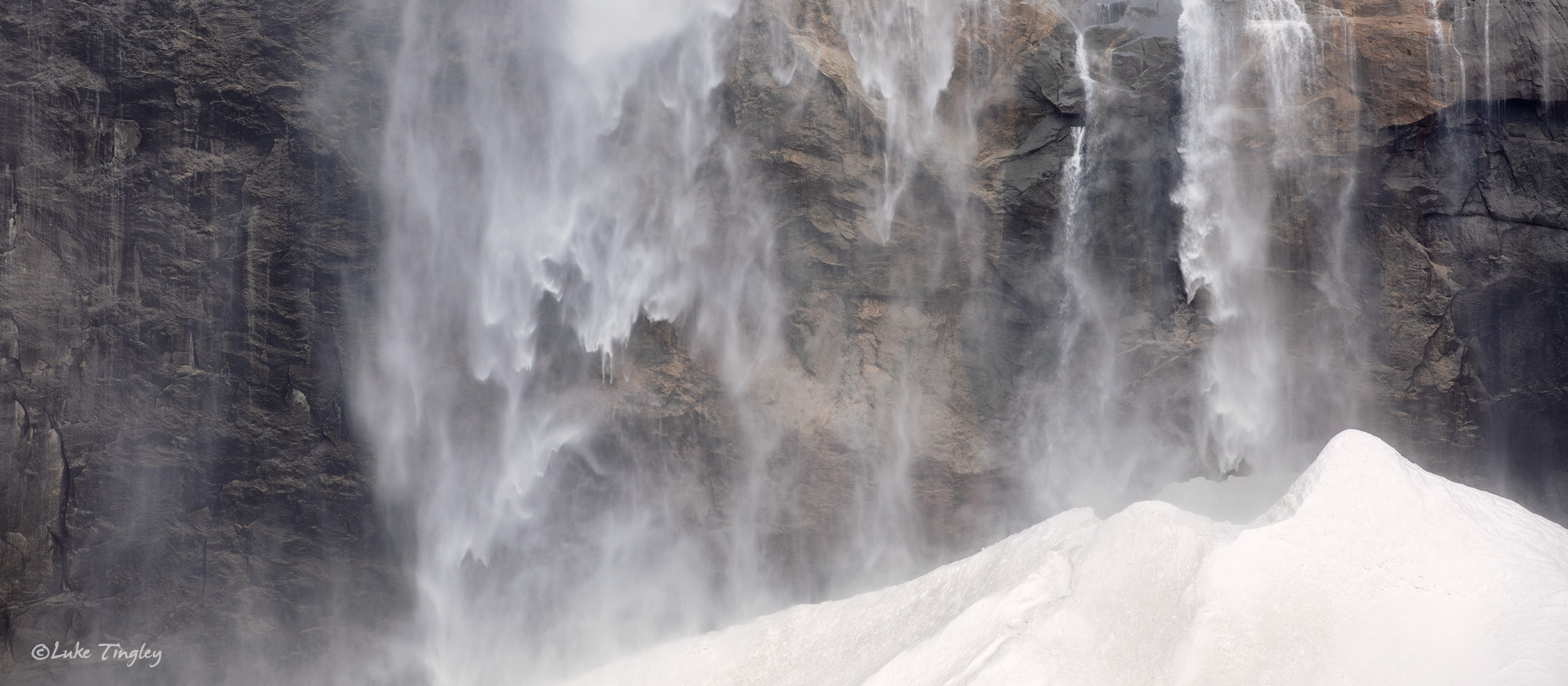 Raging sheets of water cascading into a snow cone at the base of Upper Yosemite  Falls.